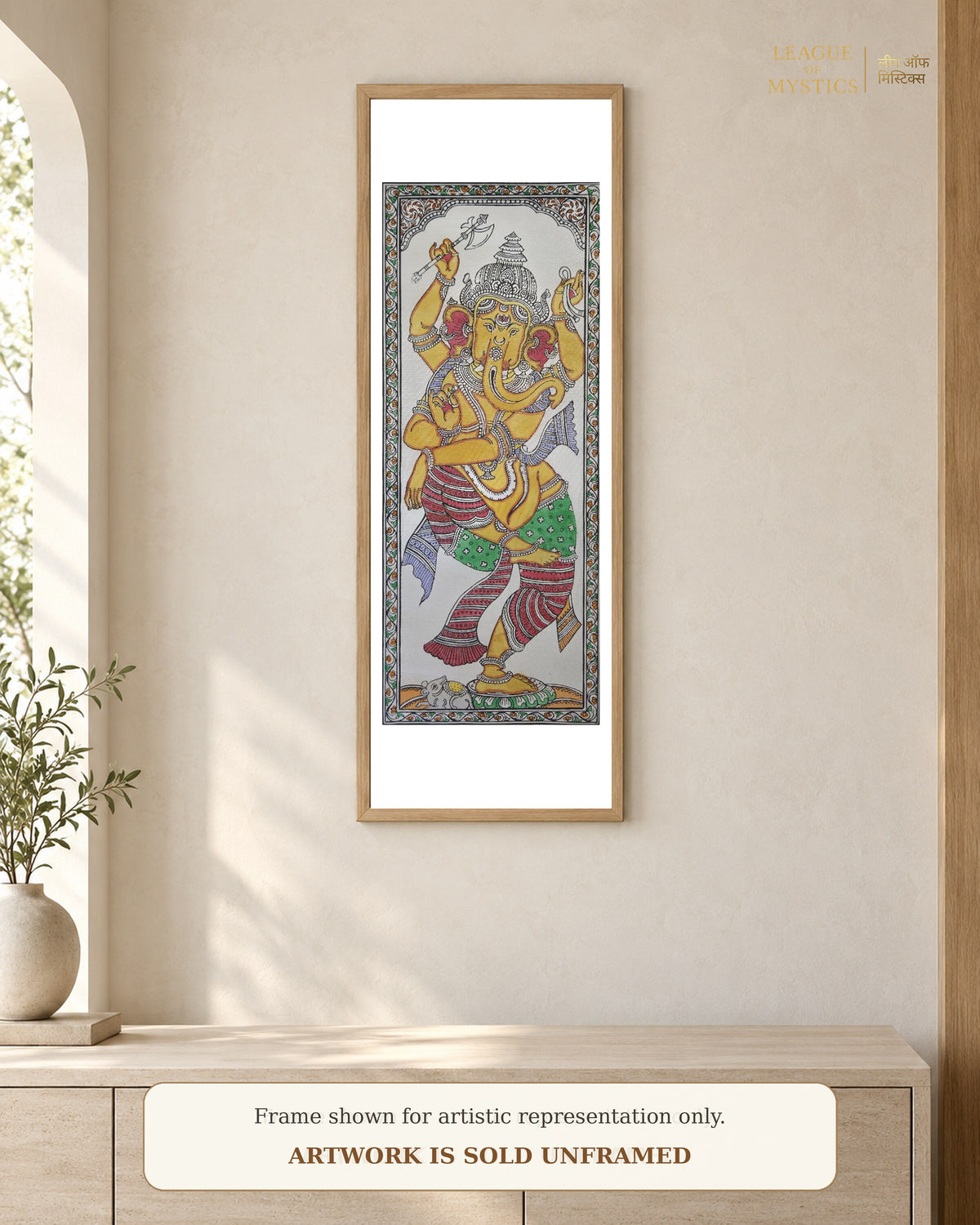 Dancing Ganesha Pattachitra shown framed on a wall, golden amber colourway